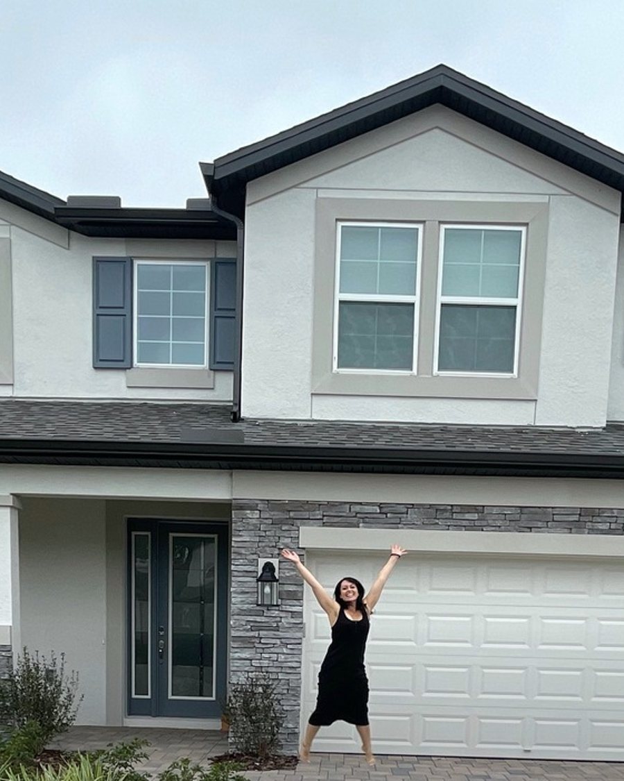Amanda in front of the house she bought after paying off her debt