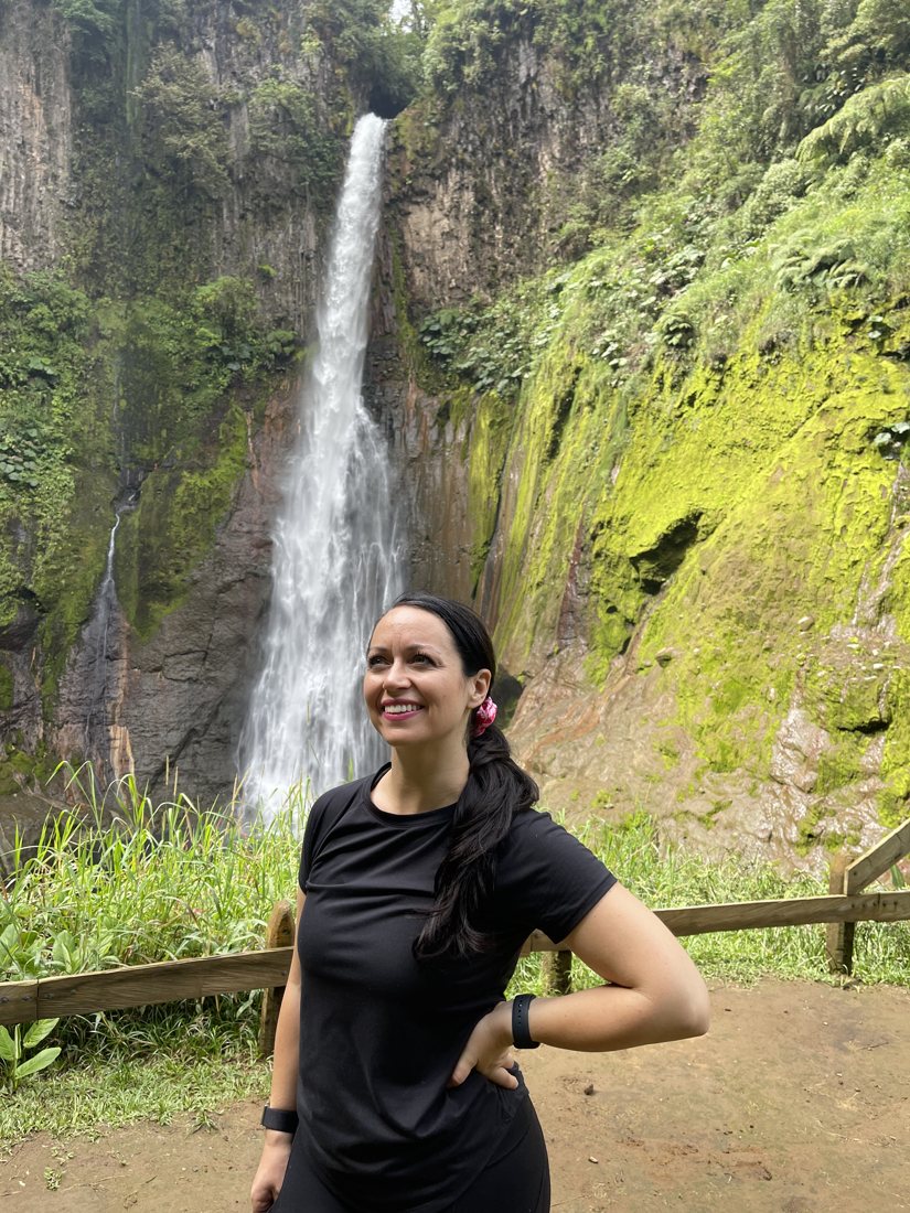 Amanda in front of a tall waterfall in Costa Rica