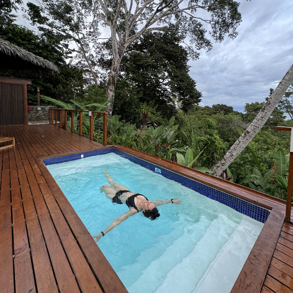 Amanda floating in a private plunge pool surrounded by jungle